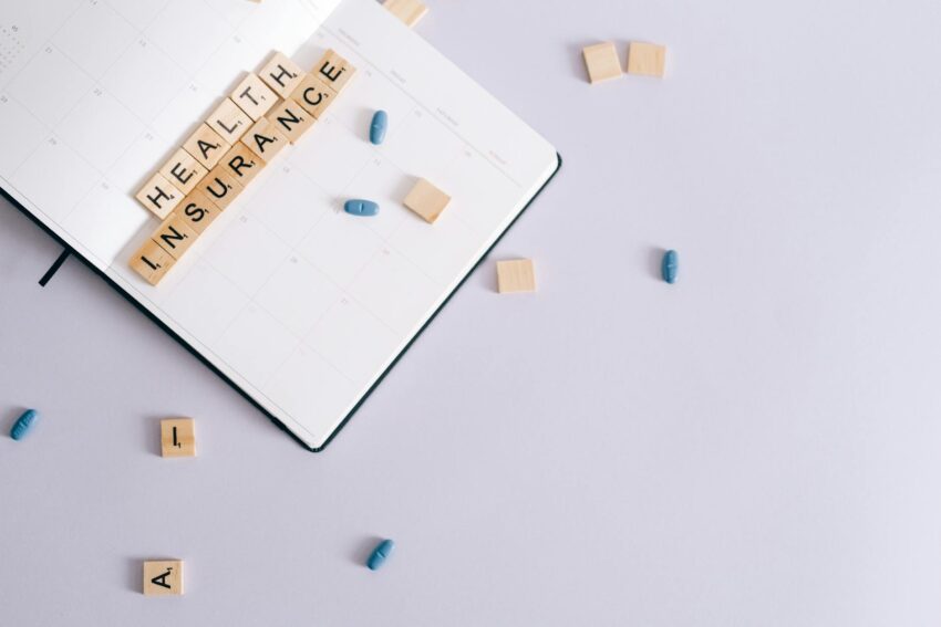 Flat lay of health insurance concept with planner and pills.
