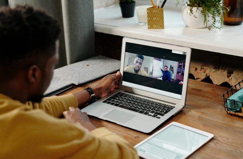 A man participates in an online video conference call from home using his laptop, fostering remote communication.