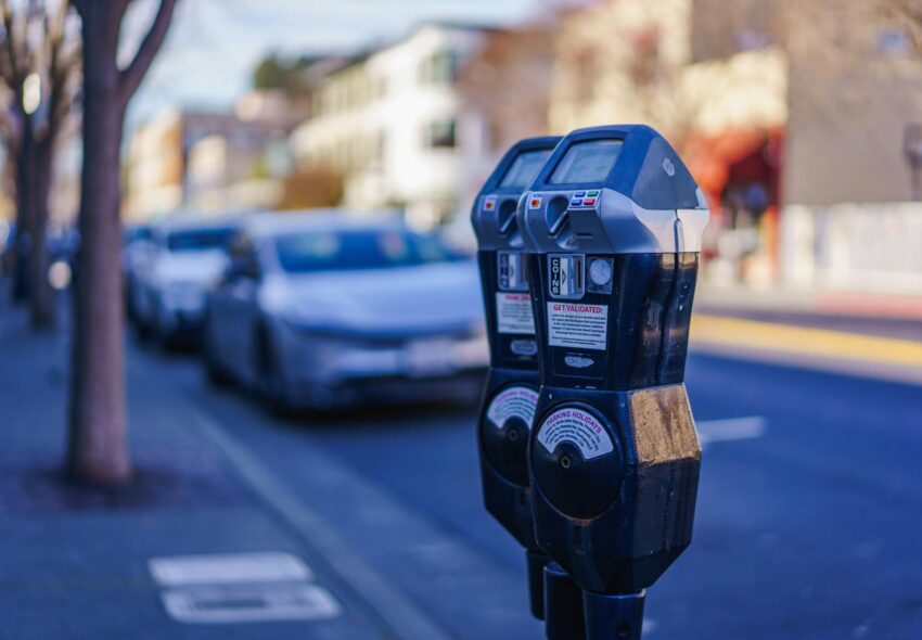 Close-up of parking meters in a bustling city street during the day, showcasing urban infrastructure.