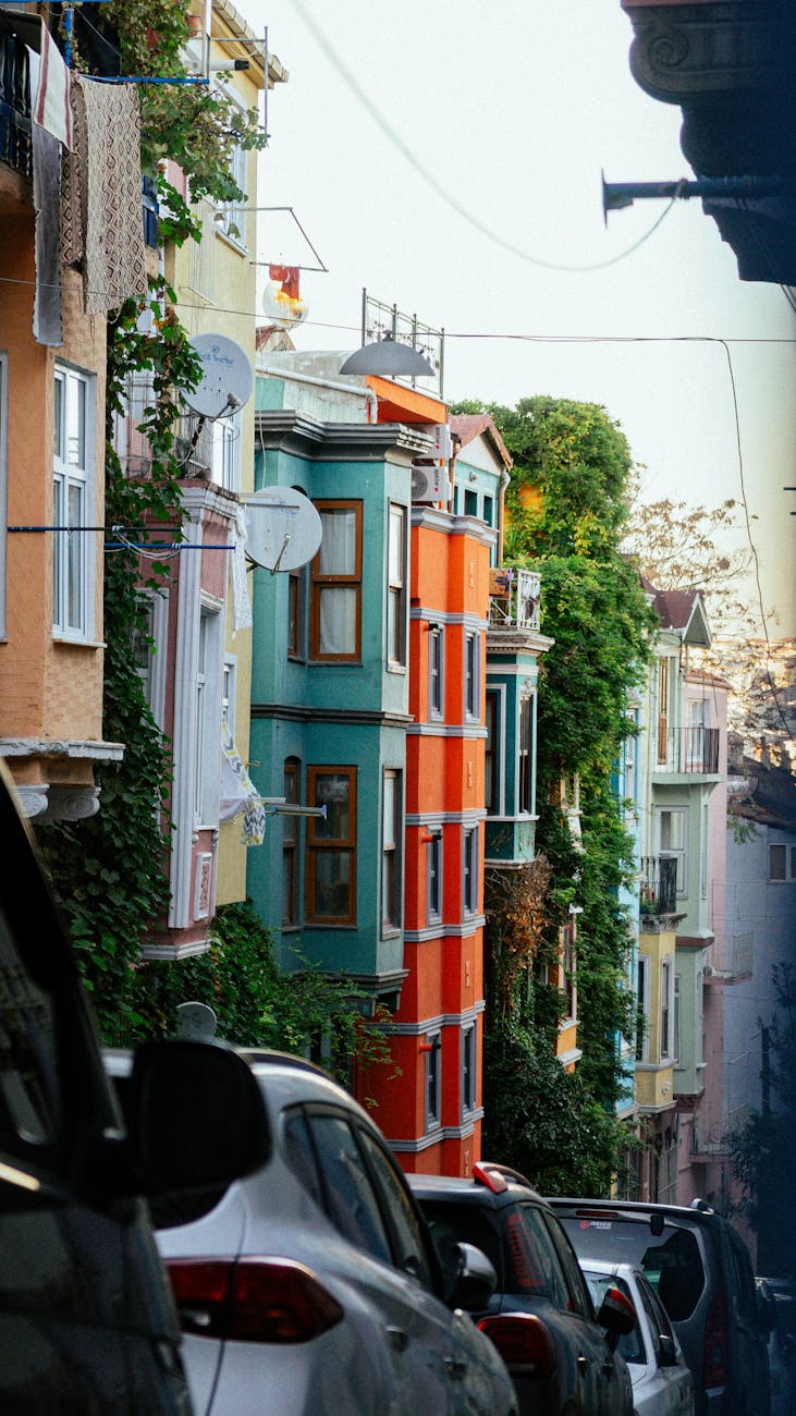 Vibrant city street with colorful buildings and parked cars, showcasing urban charm.