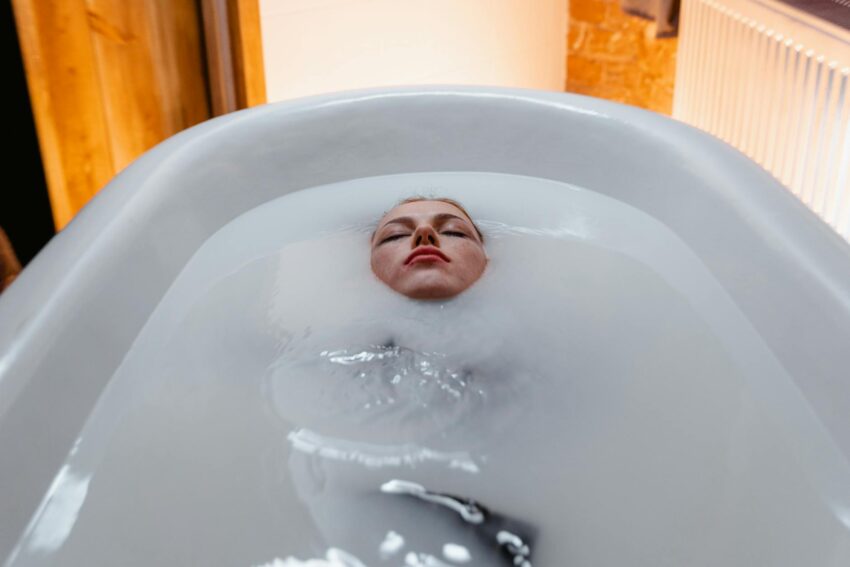 A woman floating peacefully in a bathtub, creating a serene and calming atmosphere.
