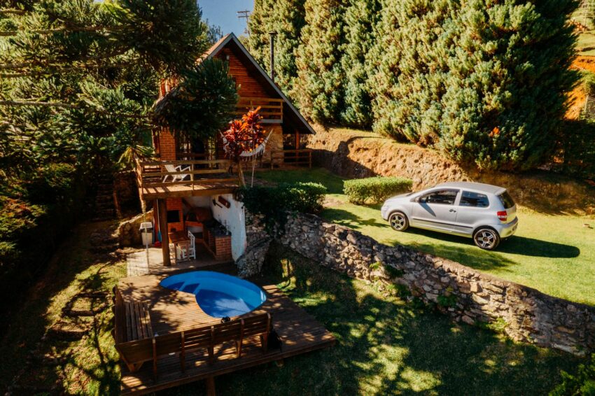 Cozy bungalow with a pool surrounded by lush trees in São Bento do Sapucaí, Brazil.