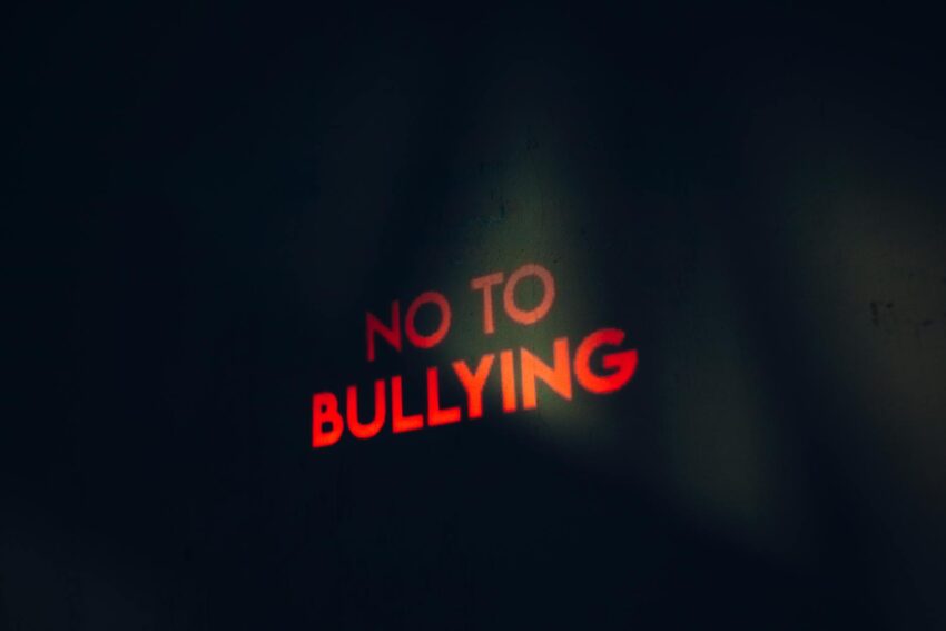 Image featuring a strong anti-bullying message boldly lit on a dark background.
