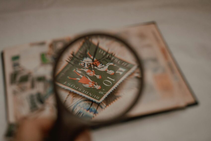 A detailed view of a vintage stamp through a magnifying glass, emphasizing collection and philatelic study.
