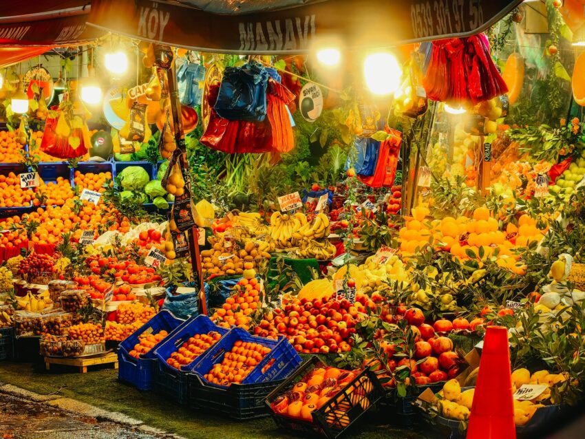 Colorful fruits and vegetables beautifully displayed at a bustling night market stall in Istanbul.