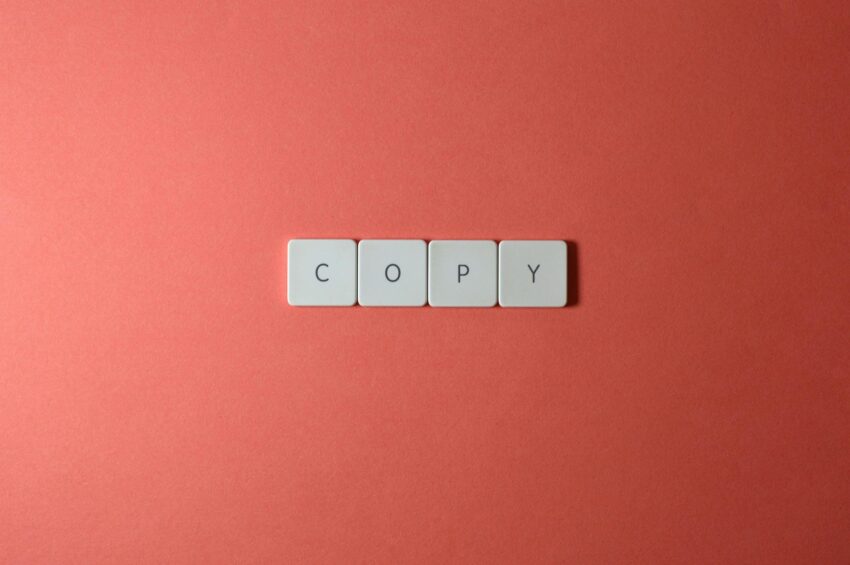 Simple arrangement of keyboard keys spelling 'COPY' on a coral surface, perfect for creative concepts.