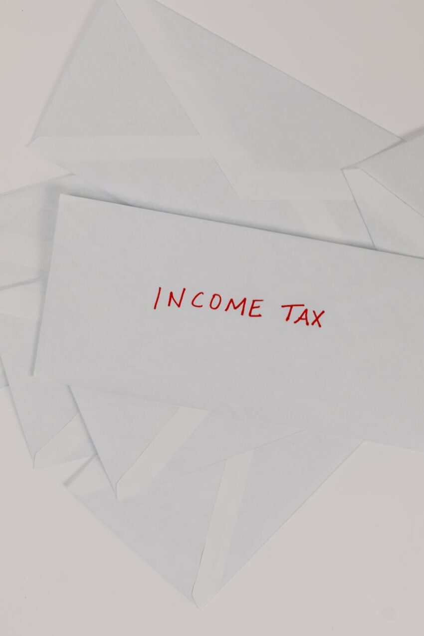 Top-down view of an envelope labeled 'Income Tax' on a white background, representing finance and taxation.