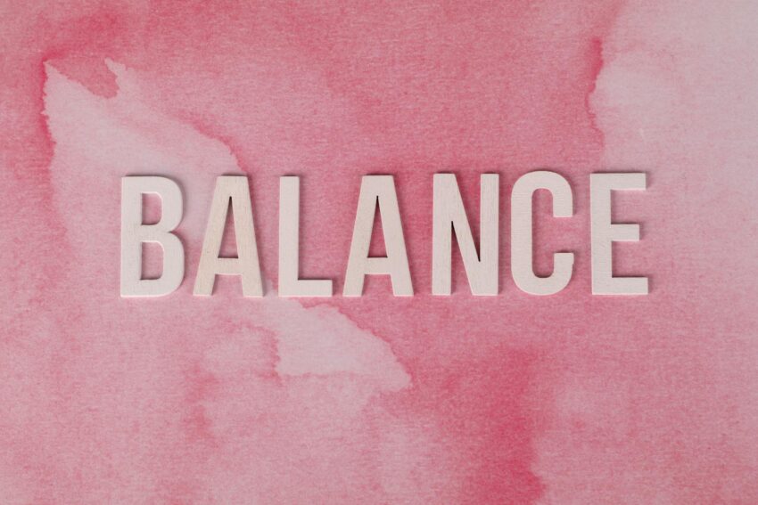 The word 'BALANCE' displayed in bold letters on a pink abstract background.