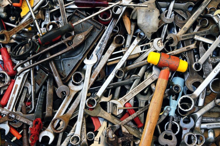 Close-up view of various tools including wrenches and a hammer, providing a cluttered yet organized look.