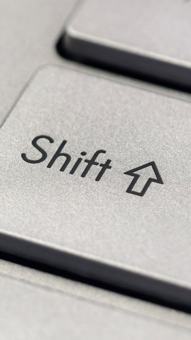 Macro photo of a silver keyboard shift key, showcasing detail and texture.