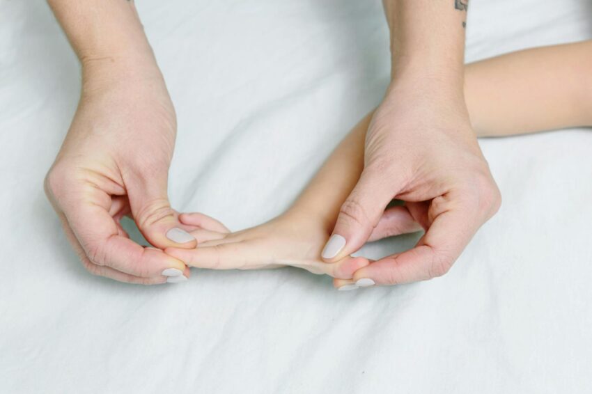 Close-up of hands giving gentle massage to child's hand, promoting relaxation.