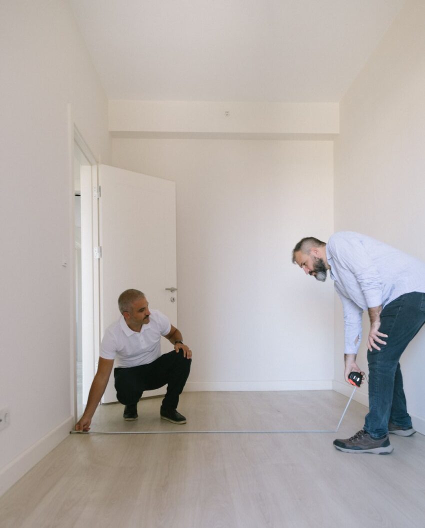 Two men measuring an empty room for renovation in Istanbul, Turkey.